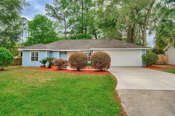 Blue ranch home with Spanish moss oaks on a tree-lined Gainesville street