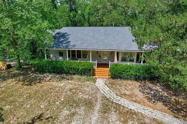 Ranch home with wrap-around porch on a wooded lot in Archer, Florida